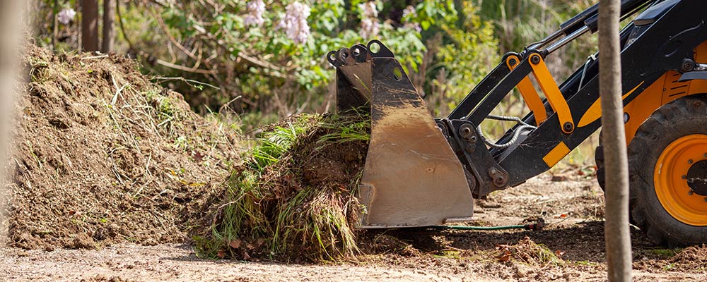 Bagger mit Gras und Erde